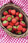Fresh strawberries in a basket on the background of a checkered tablecloth