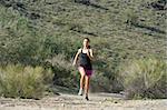 Young woman trail running outdoors at South Mountain Park in Phoenix, Arizona.