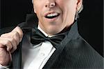 Close-up of a man in a tux doing an Elvis impression.