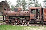 Antique rusty broken steam locomotive standing on rails