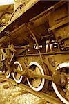 Closeup of antique rusty broken steam locomotive standing on rails