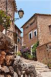 Narrow street old traditional houses village with flowers, Fornalutx, Majorca island