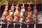 Shashlik (shish kebab) prepared on the metal skewers outdoors in summertime