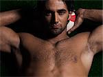 one caucasian sexy topless man portrait hugging a rugby ball on studio black background