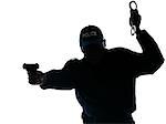 Silhouetted Afro American policeman aiming handgun while holding handcuffs isolated on white background