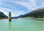 Flooded (in 1950) bell tower in Reschensee and family (Italy, church building in 14th-century)