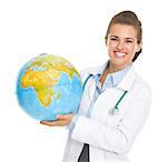 Smiling doctor woman holding earth globe