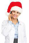 Smiling doctor woman in santa hat talking cell phone