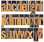 complete English lowercase alphabet - a collage of 26 isolated antique wood letterpress printing blocks, scratched and stained by inks