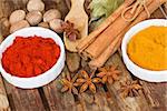 colorful spices of curry and red pepper with seeds of anise and nutmeg on wooden table