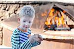 positive adorable kid eating smores by the fire