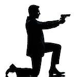 one caucasian spy criminal policeman detective man aiming shooting gun  full length silhouette in studio isolated white background