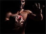 one caucasian sexy topless man portrait hugging a rugby ball on studio black background