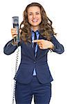 Smiling business woman pointing on phone handset