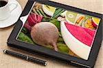 reviewing pictures and recipe for vegetable cream soup on a digital tablet