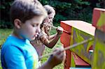 Children painting cardboard boxes, Munich, Bavaria, Germany