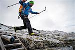 Hiker jumping across mountain stream, Norway, Europe