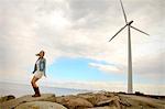Young woman on the waterfront, wind turbine in background, Denmark, Europe