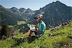 Mountain biker looking at map, Kleinwalsertal, Vorarlberg, Austria