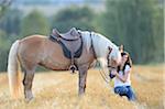 Young Woman Sitting beside Haflinger Horse in threshed Cornfield, Bavaria, Germany