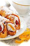 Cannoli on white plate and candied oranges.