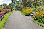 Neighborhood Public Parks Lined with Colorful Flowers Trees and Shrubs with Park Bench