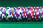 Colorful poker chips closeup on green cloth
