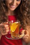 Closeup on ginger tea with lemon in hand of young woman