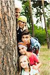 Portrait of group of children posing next to tree in park, Germany