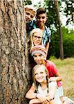 Portrait of group of children posing next to tree in park, Germany