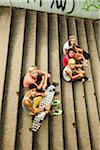 Group of children sitting on stairs outdoors, looking up at camera, Germany