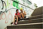 Girls Sitting on Steps with Tablet Computers and Skateboard, Mannheim, Baden-Wurttemberg, Germany