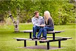 Young Couple Sitting on Picnic Table, Scanlon Creek Conservation Area, Bradford, Ontario, Canada