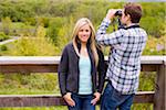 Young Couple on Lookout, Man using Binoculars, Woman looking at Camera, Scanlon Creek Conservation Area, Bradford, Ontario, Canada