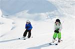 Brother and sister skiing, Les Arcs, Haute-Savoie, France