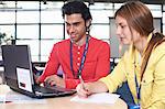 Two college students using laptop