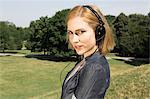 Young woman wearing headphones in park