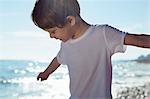 Boy with arms outstretched on beach