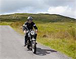 Senior male motorcyclist riding on rural road