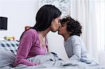 Son kissing mother in bed
