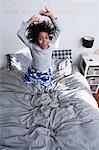 Boy jumping on bed with arms up