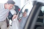 Mid adult man looking at car in showroom