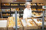 Young sales assistant holding sweet pastries