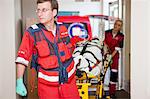 Paramedics wheeling stretcher through hospital