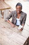 Young woman holding coffee cup in street cafe