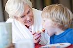 Grandmother feeding grandson breakfast