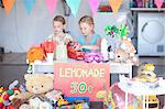 Two young sisters setting up stall