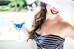 Young woman holding blue cocktail