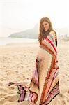 Young woman wrapped in blanket,  Ipanema Beach, Rio de Janeiro, Brazil