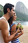 Portrait of couple on beach with Sugarloaf Mountain, Rio de Janeiro, Brazil